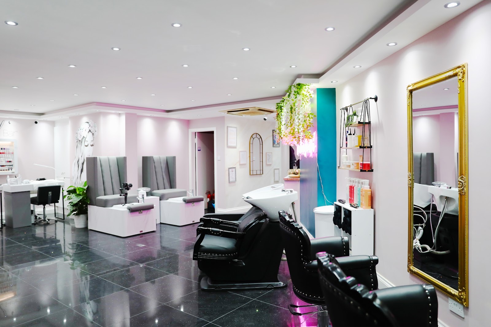 Inside MyBeautyHub in Bow, a bright salon with nail stations, hair wash chairs, a gold-framed mirror and pink walls
